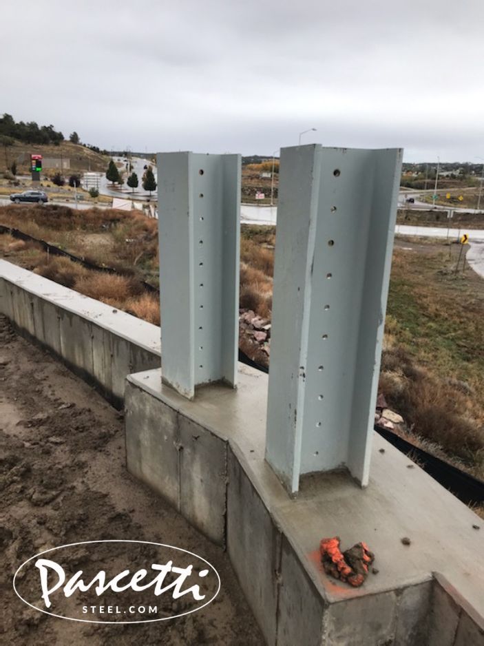 External high tension cable barrier system for perimeter safety with large steel beams set into concrete wall
